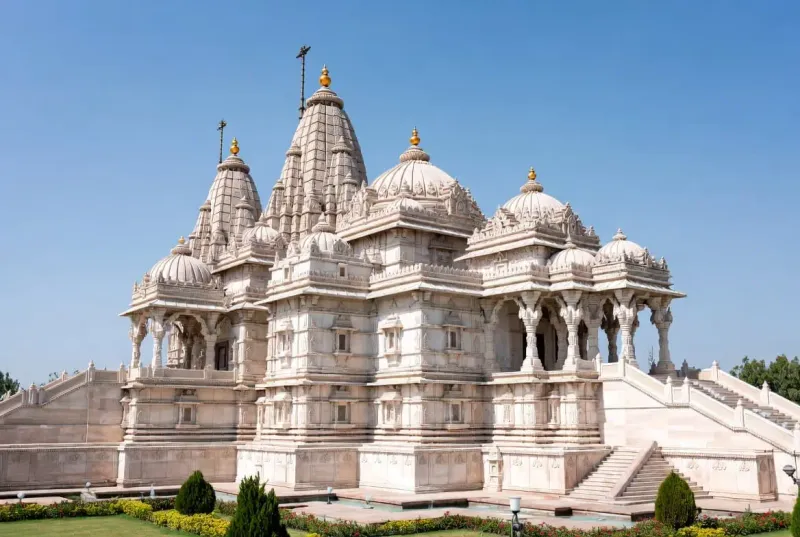 The grand pink sandstone facades and intricately carved pillars of Akshardham Temple in Jaipur